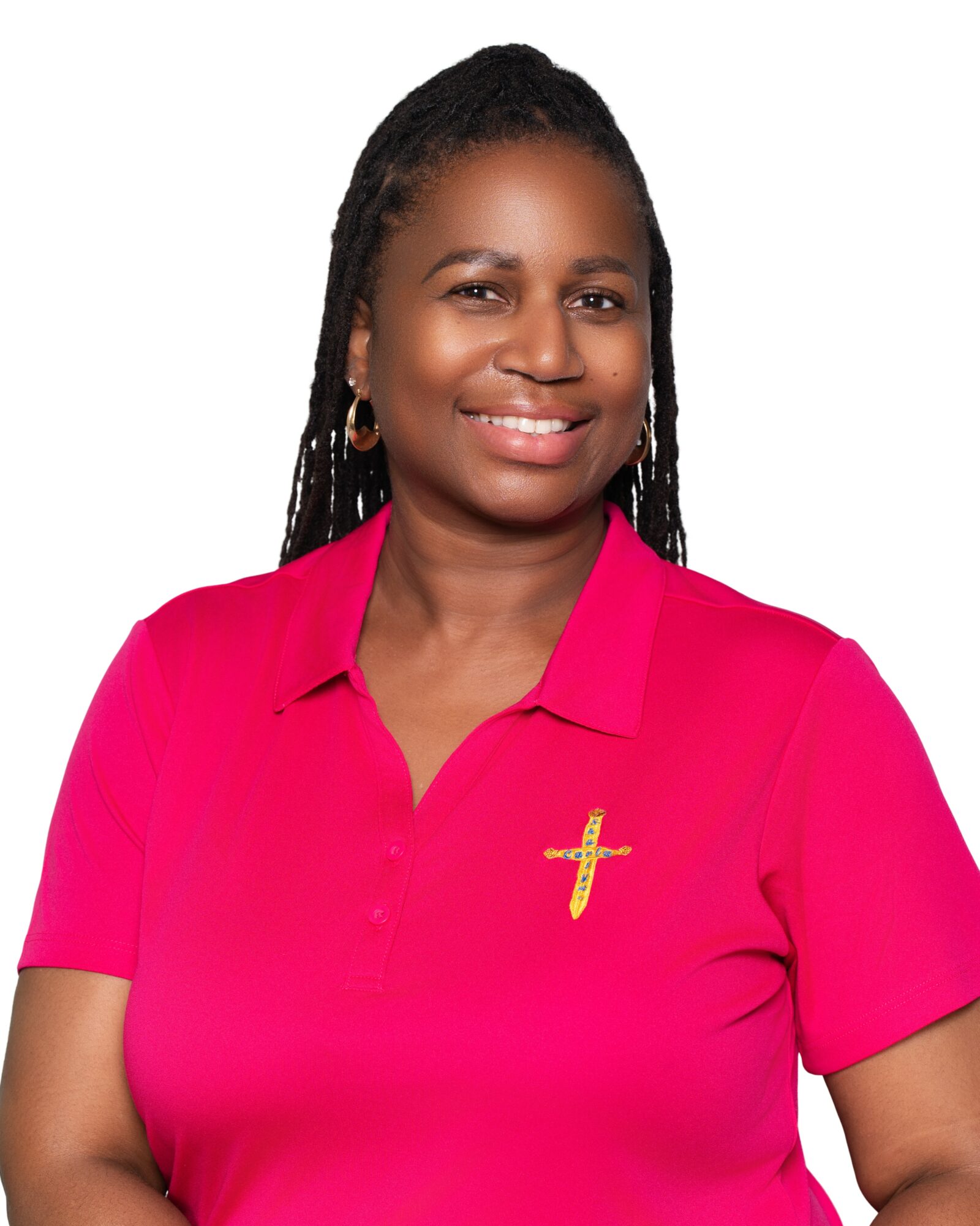 Smiling woman with braided hair wearing a pink shirt with a gold cross pin, against a white background.