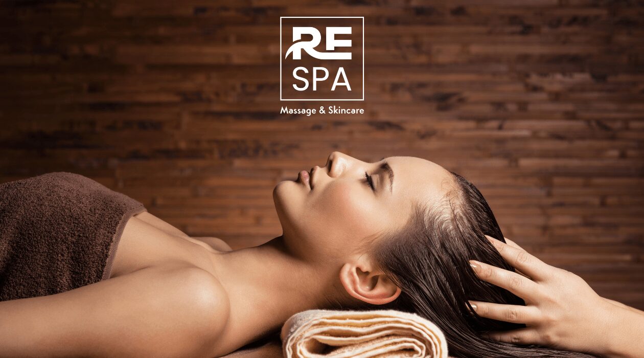 Woman lying down with eyes closed, receiving a massage, with a towel under her head, in a spa setting.