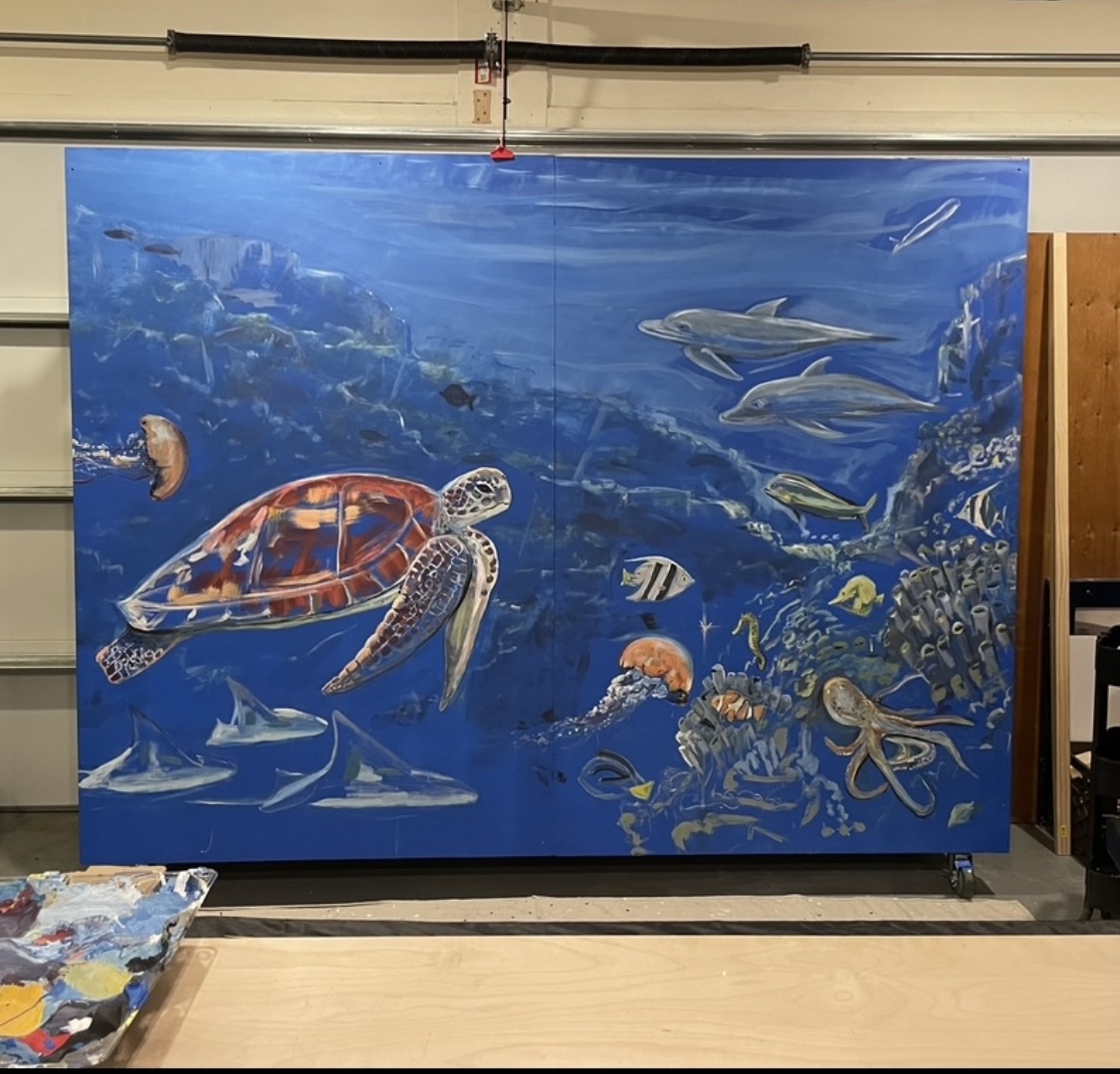 Underwater scene with a turtle, various fish, and coral reef, painted on a large blue backdrop.