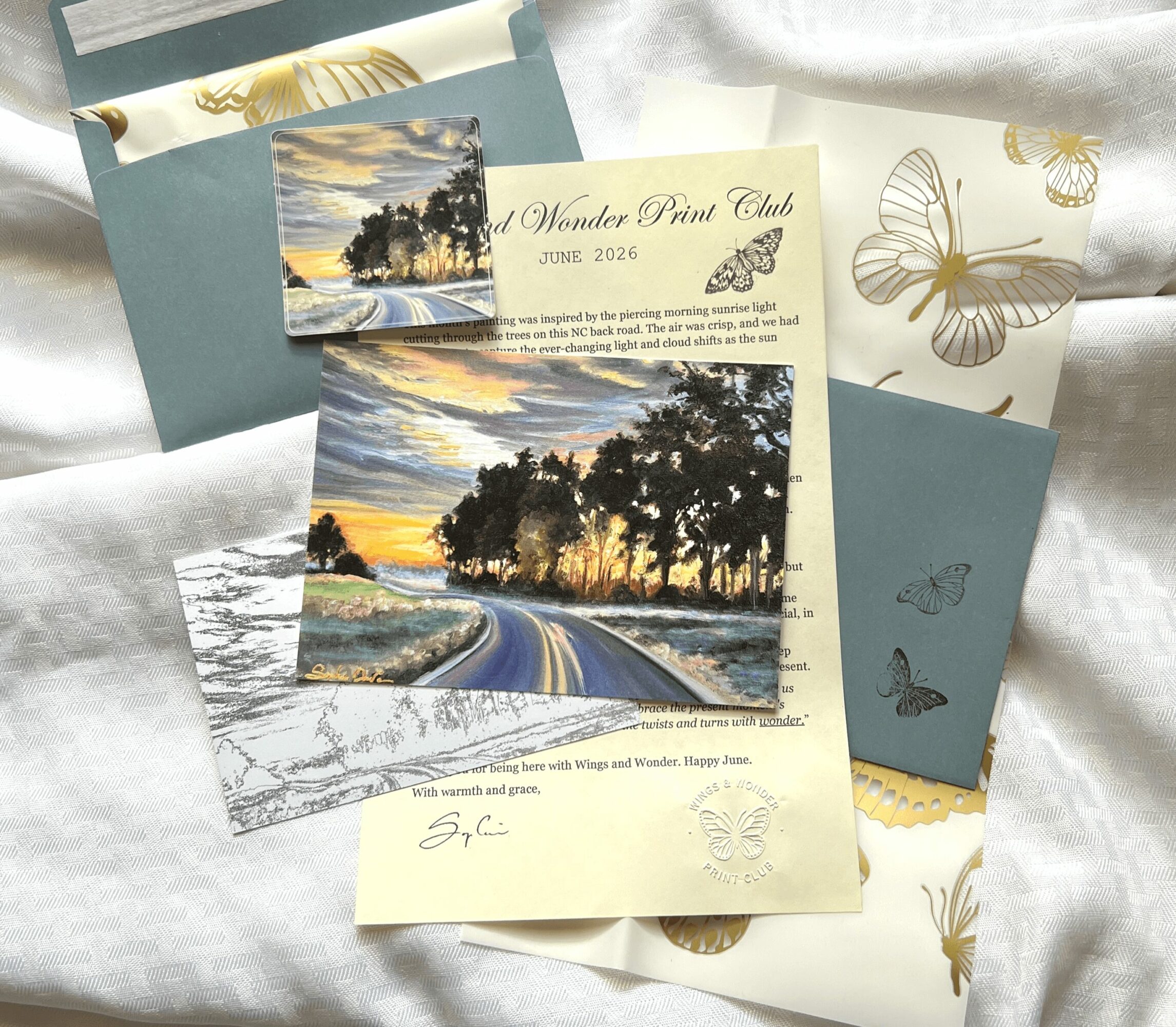 Collection of postcards and papers with landscape and butterfly designs, some with sunset scenes and handwritten notes.