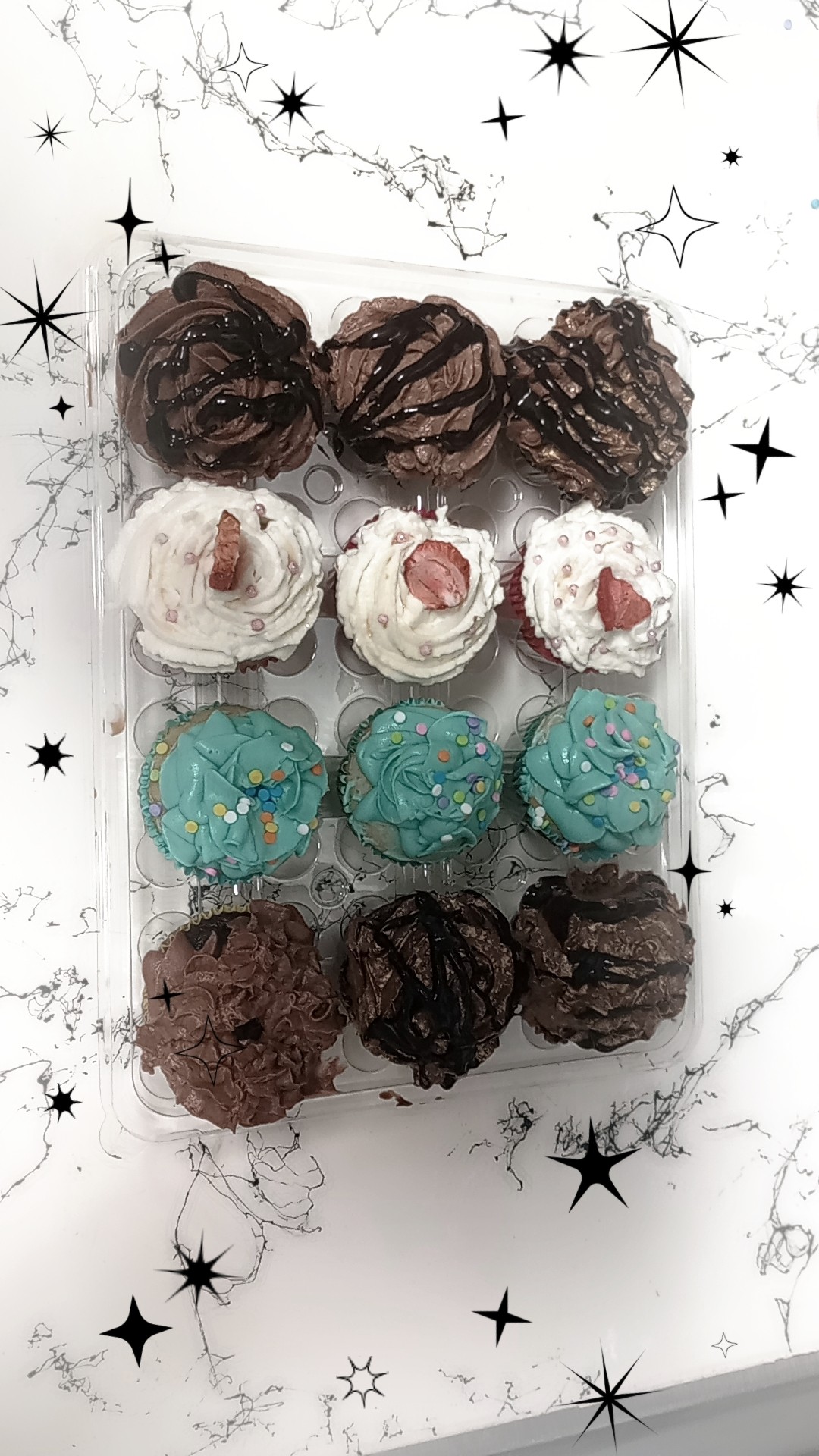 Three rows of assorted cupcakes with different toppings on a white background with black star and sparkle illustrations.