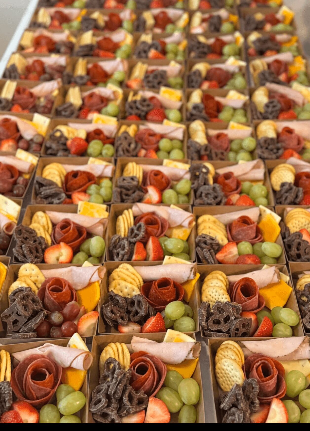 Multiple small boxes filled with assorted candies and chocolates, arranged in rows, with various shapes and colors.