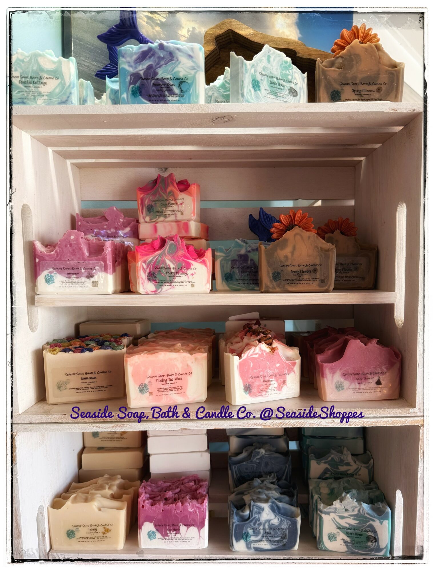 Shelf with colorful bath and candle products arranged in rows, with a purple text label at the bottom.