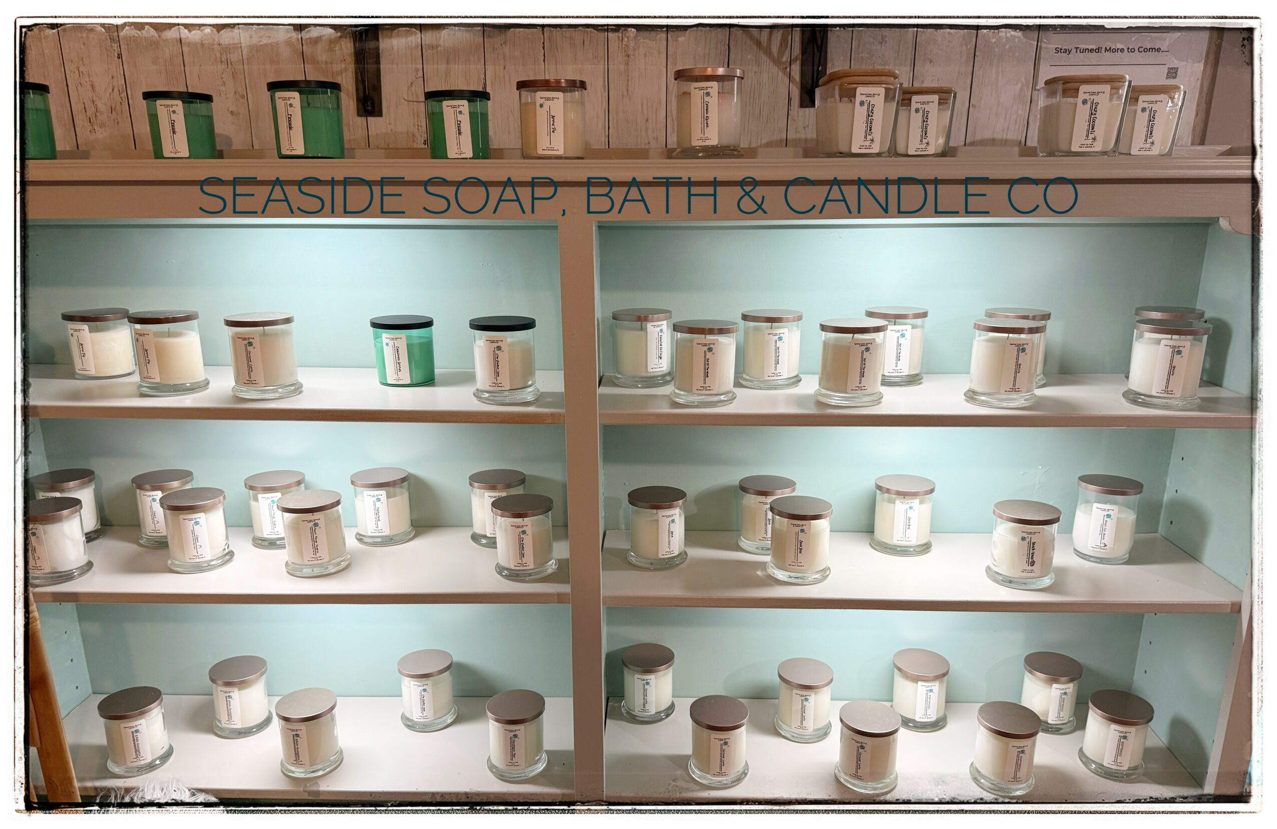 Shelves with candles and soap products, sign reads 'Seaside Soap, Bath & Candle Co.', display in store.