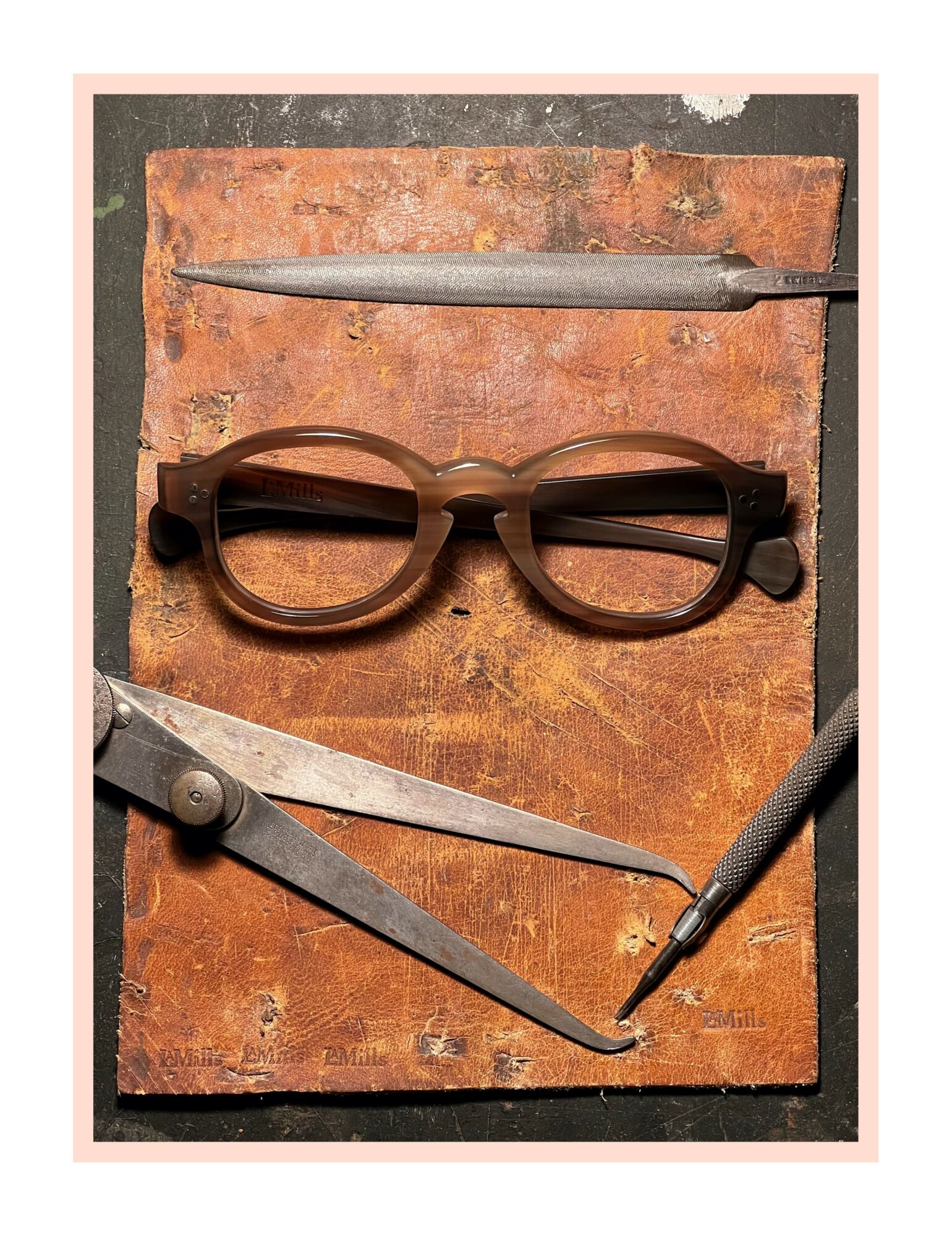 Eyeglasses, a pen, a compass, and a mechanical pencil on a wooden surface.