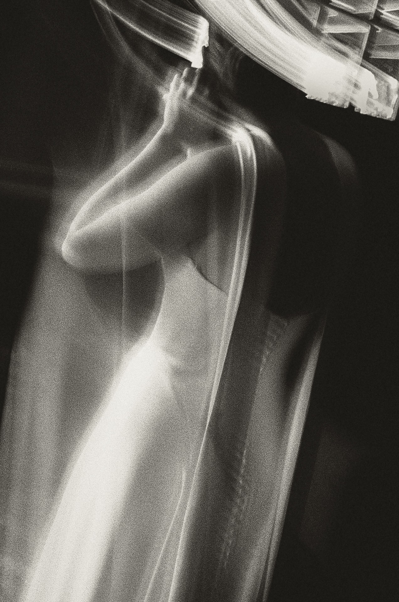 Blurred black and white photo of a person taking a mirror selfie, with light streaks and motion effects.