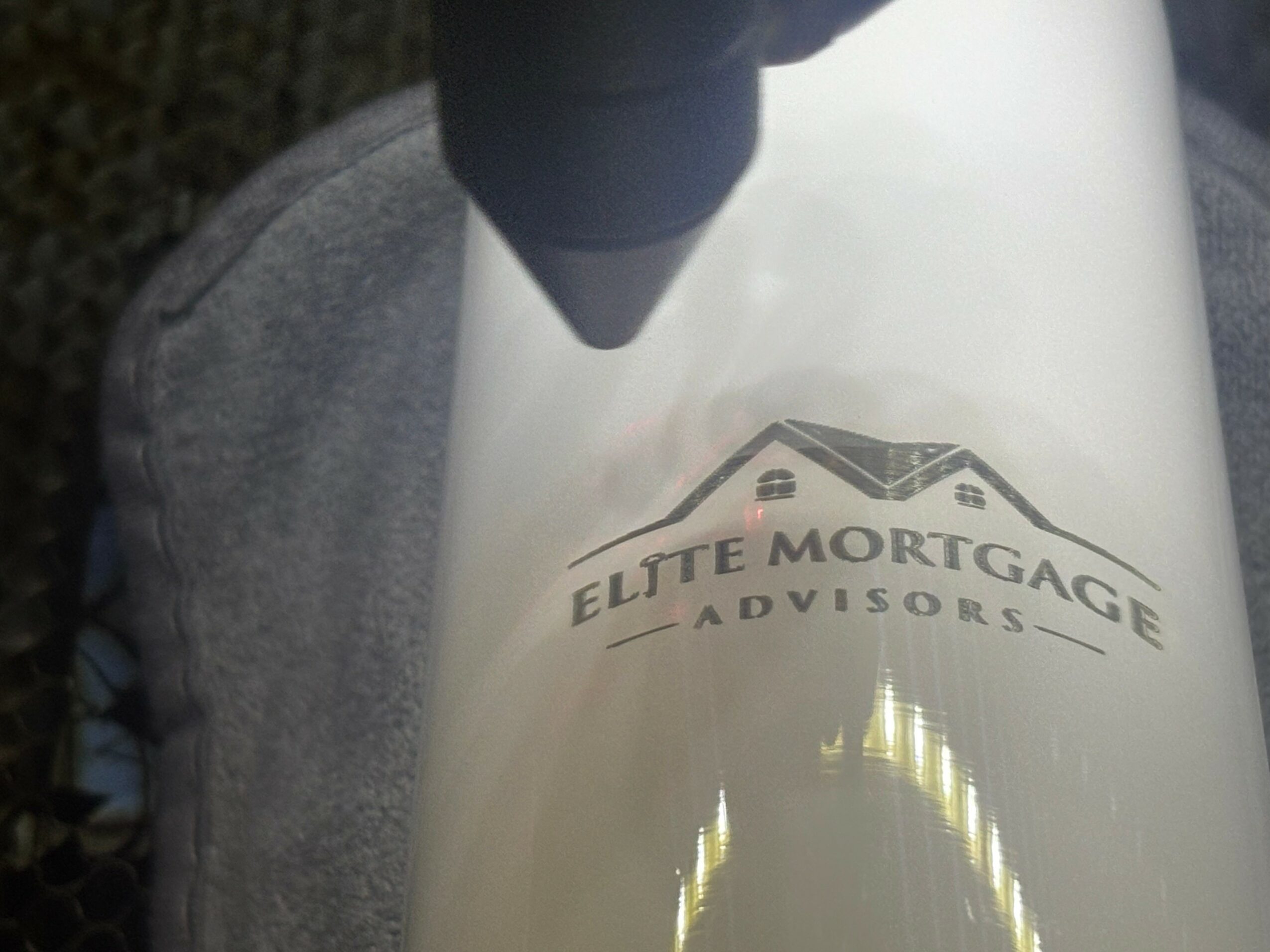 Close-up of a white container with the logo and text 'Elite Mortgage Advisors' visible.