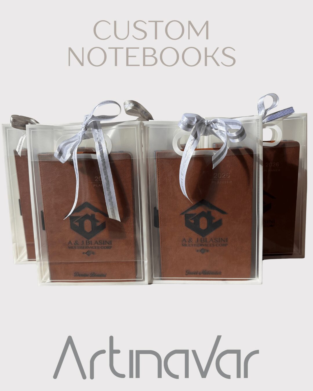 Three transparent notebooks with brown covers and white ribbons, labeled 'Custom Notebooks' and 'ArtinaVar'.