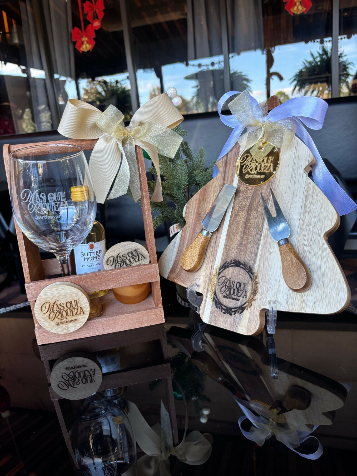 Gift set with wooden utensils, a small bottle, and decorative tags, arranged on a table with a window in the background.