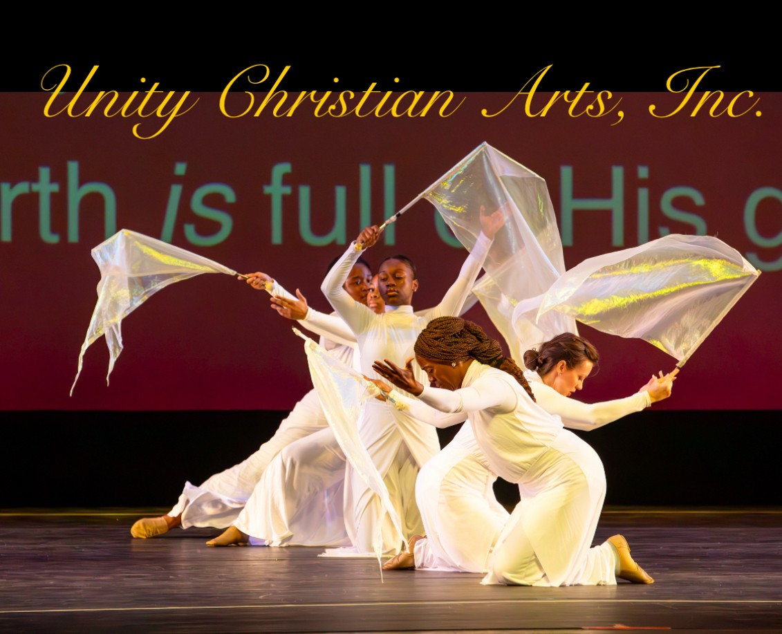 Three dancers in white costumes perform on stage with flowing fabric, with text in the background reading 'Unity Christian Arts, Inc.'