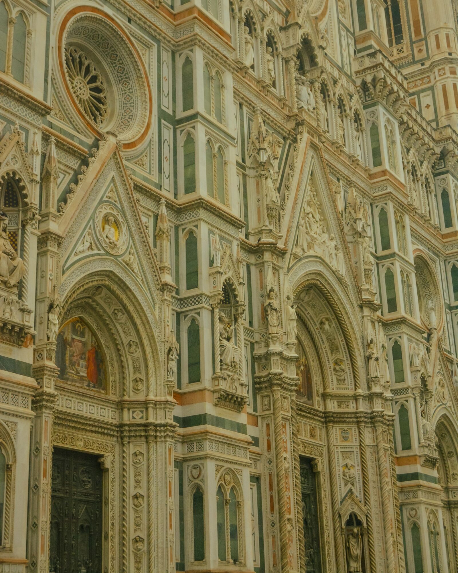 Detailed view of ornate architectural facade with arches, columns, and decorative elements in pastel colors.