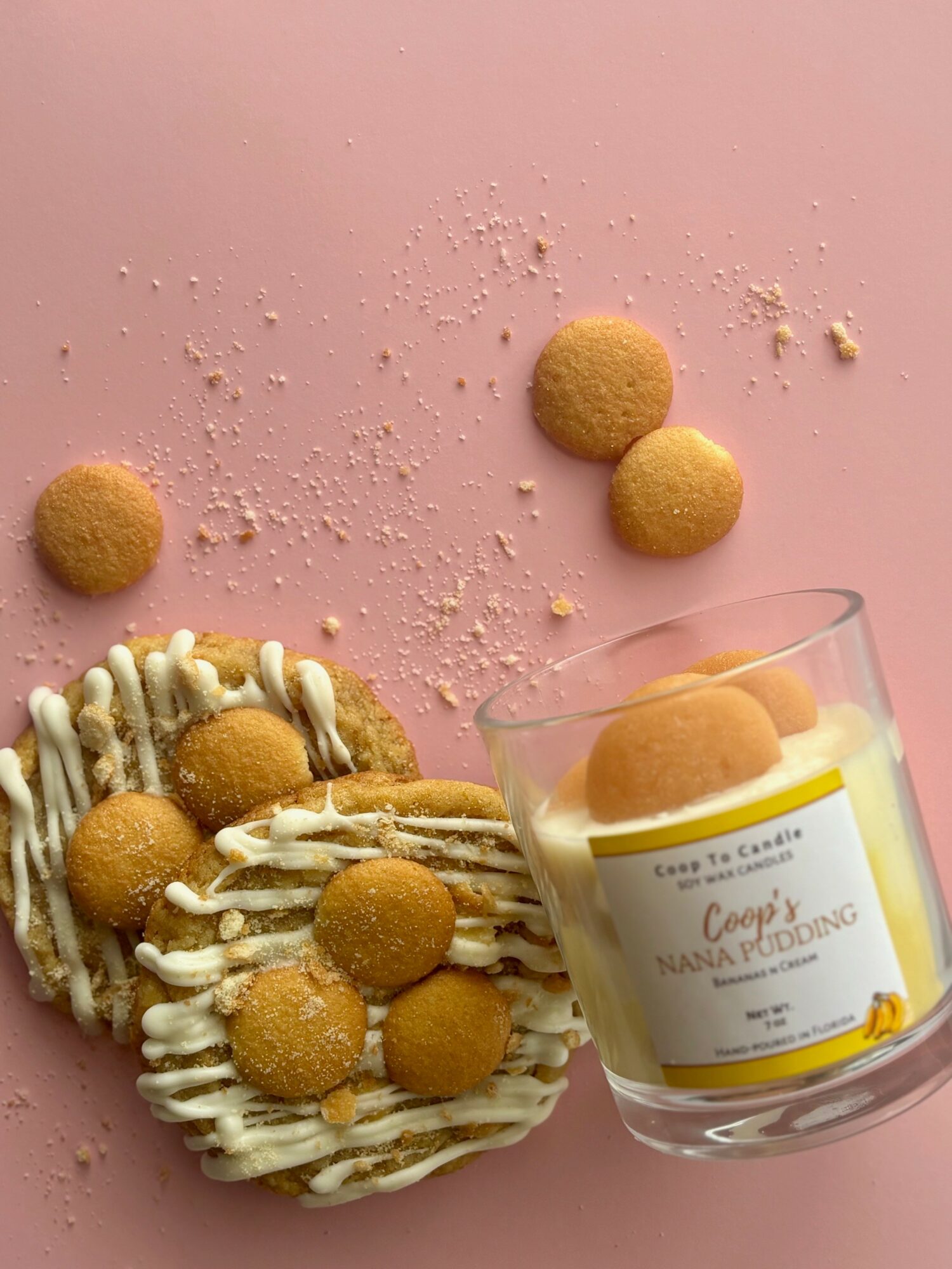 Cookies and cream dessert with round cookies on pink background, some cookies in a glass container, and scattered crumbs.