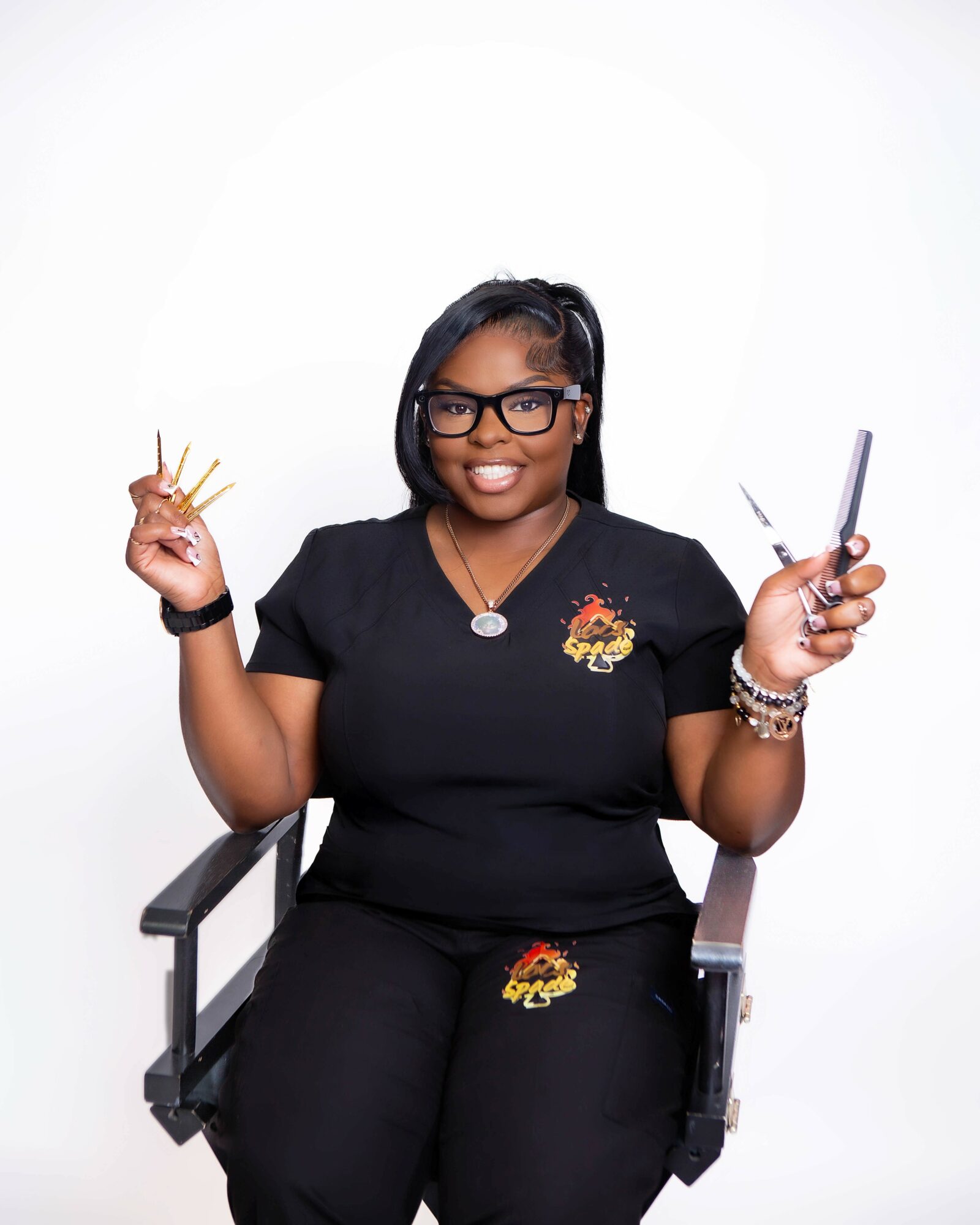 Smiling woman with glasses holding a syringe and a small container, sitting on a chair, against a white background.
