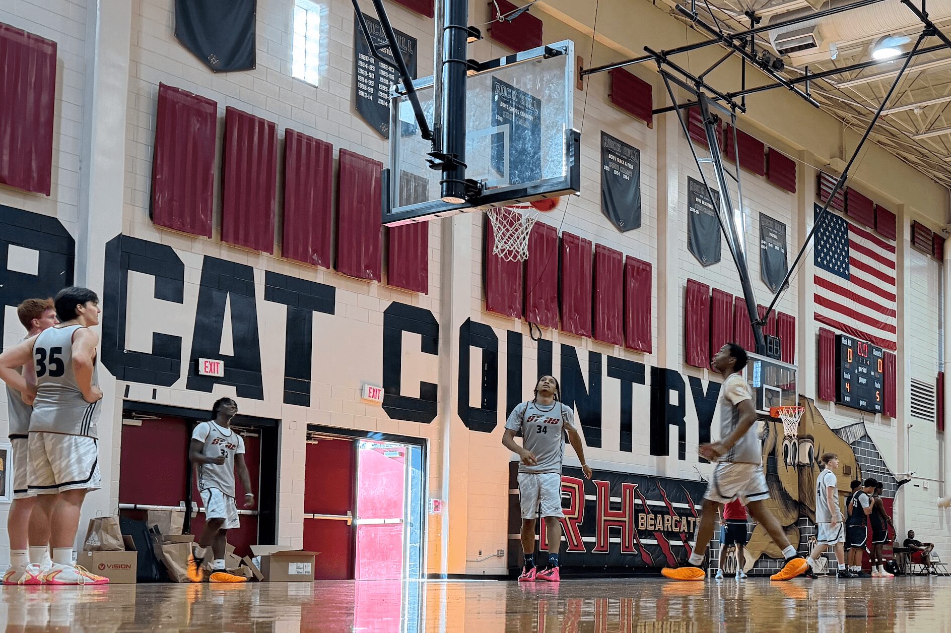 Basketball players practice on a gym court with