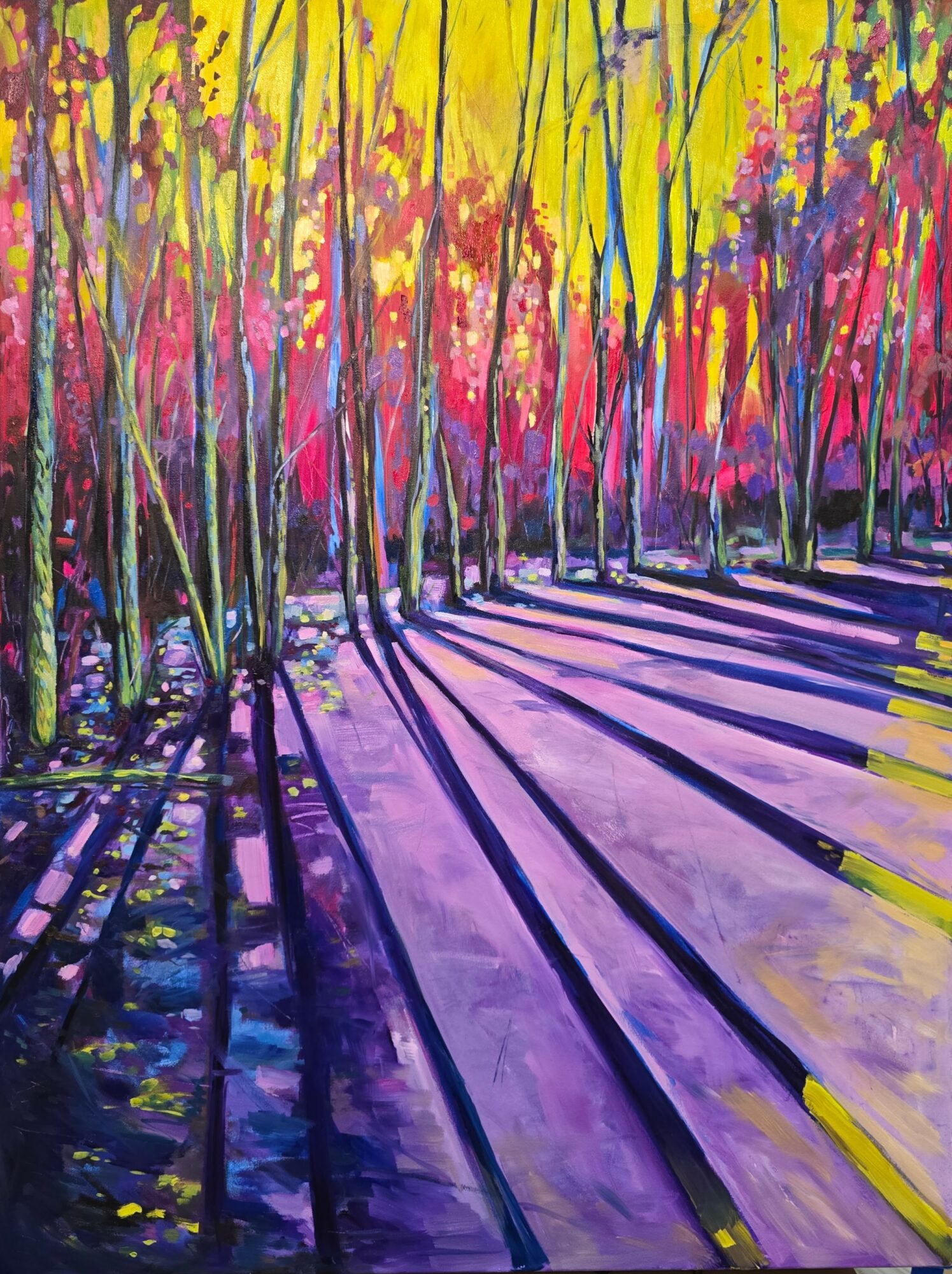 Sunlight filters through colorful trees casting long purple shadows on the ground.