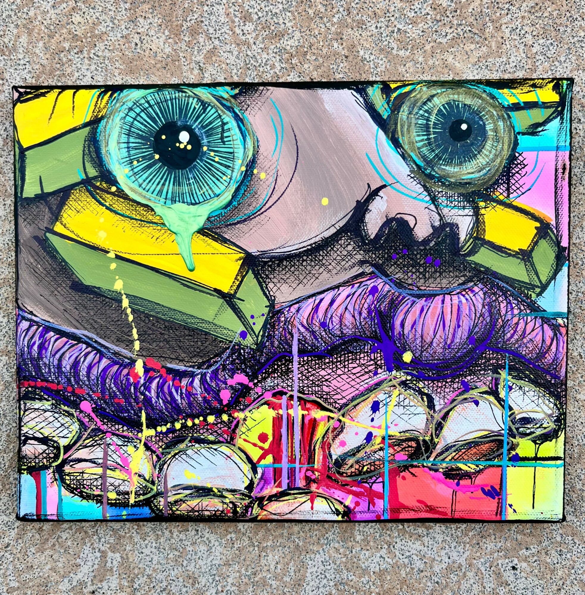 Colorful abstract artwork with large blue eyes, purple lips, and vibrant splashes of paint, on a textured surface.