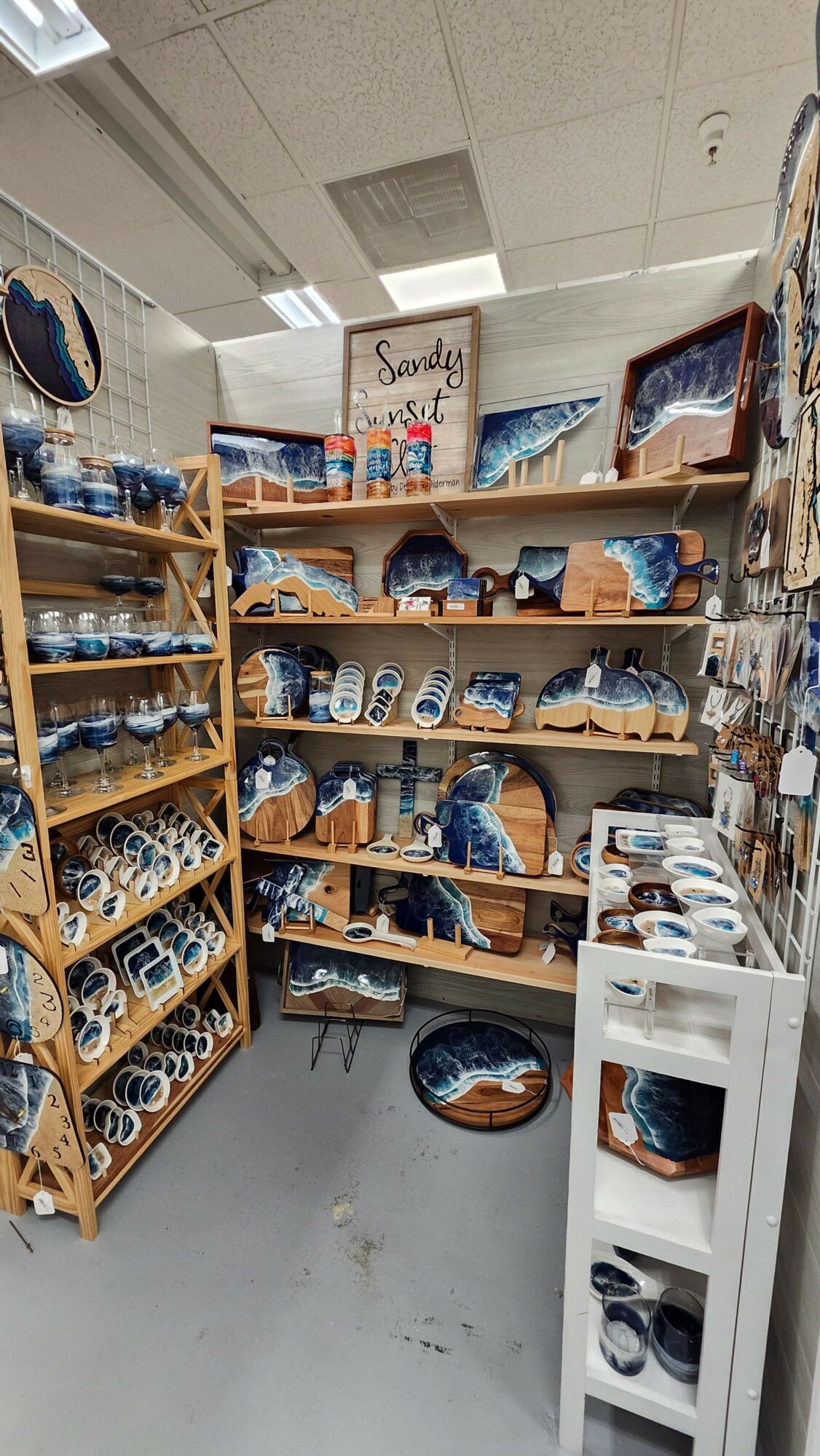 Display of blue and white ceramic dishes and bowls on wooden shelves in a store, with a white counter nearby.