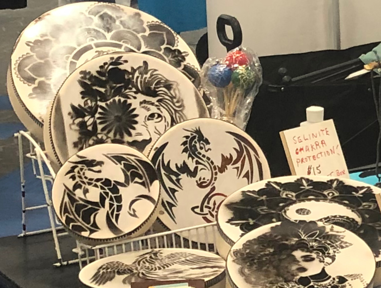 Collection of decorative plates with black and white floral and animal designs displayed on a stand.