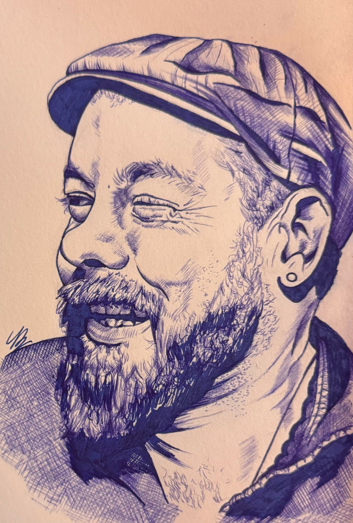 Sketch of a smiling man with a beard, wearing a cap and earring, facing slightly to the left.