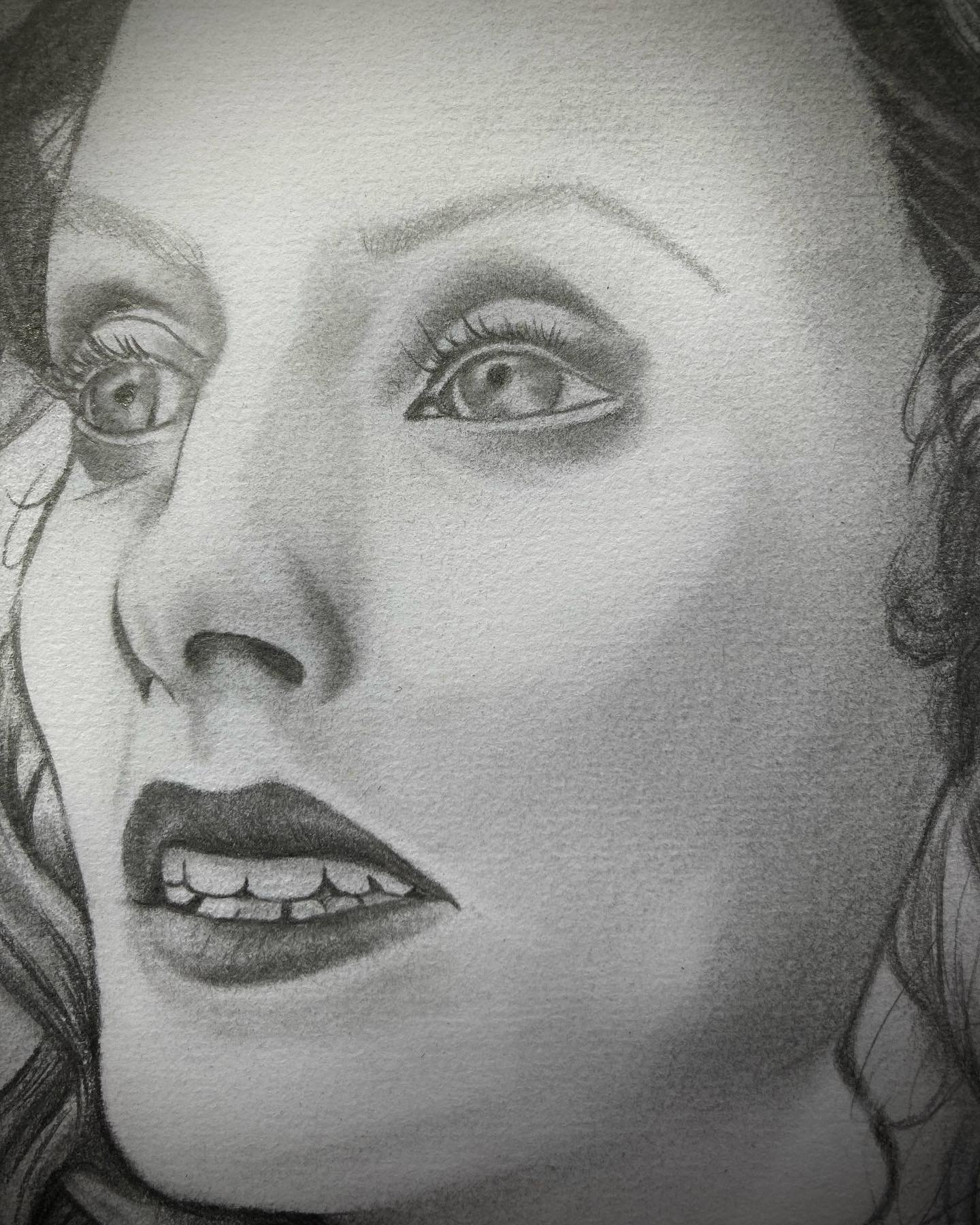 Close-up of a woman's face with detailed eyes, nose, and lips, in black and white.