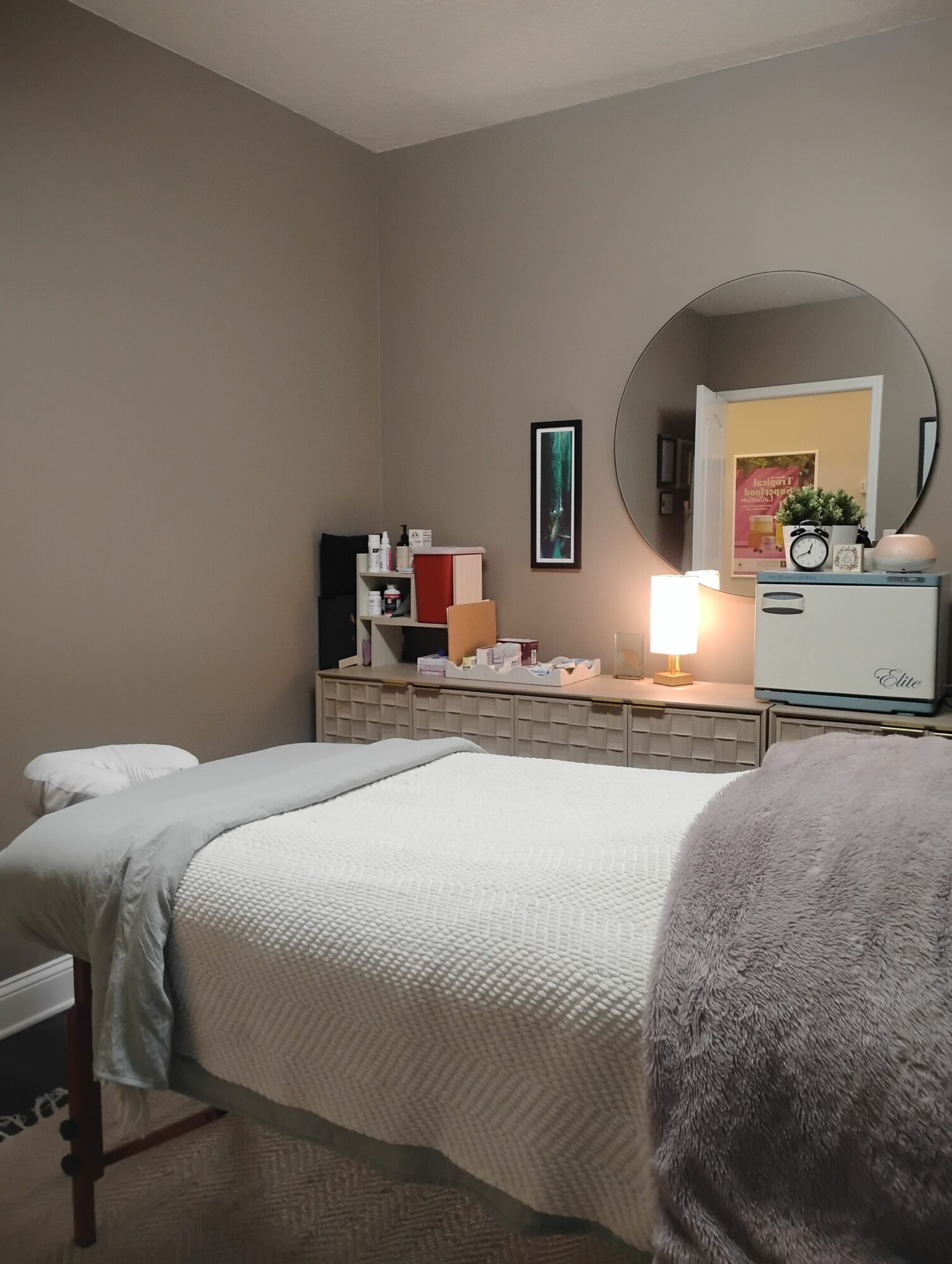 Bedroom with a bed, nightstand, lamp, and wall art, viewed from the side.