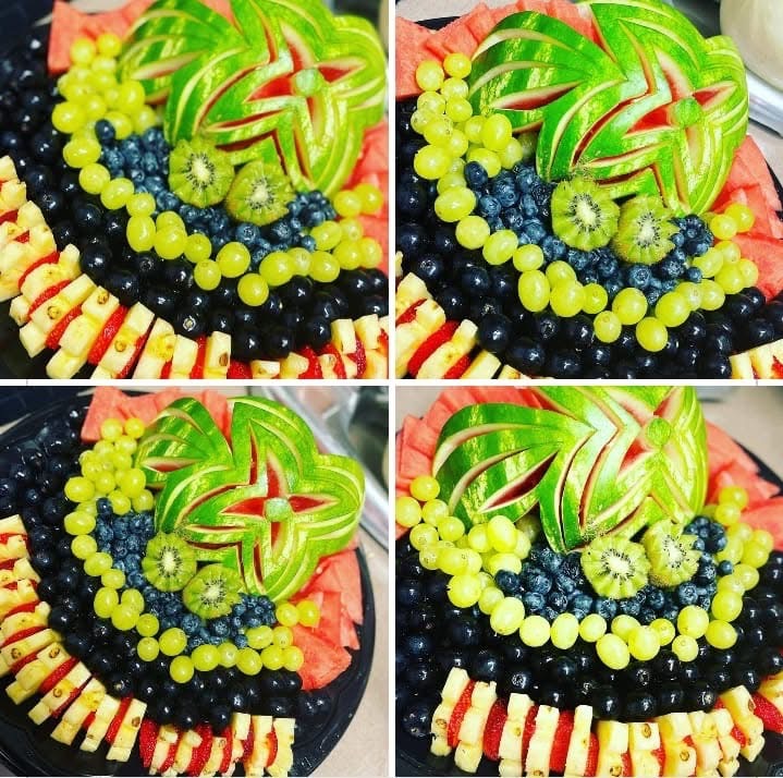 Colorful fruit arrangement with watermelon, kiwi, blueberries, grapes, and sliced fruit on a black background.