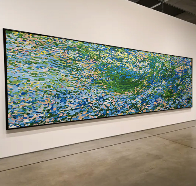 Long horizontal painting with colorful abstract water lily scene on a white gallery wall.