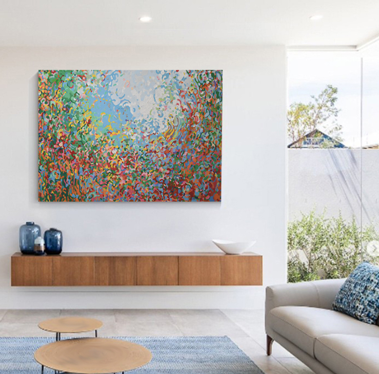 Abstract colorful painting on white wall above wooden console, with blue vases, white bowl, sofa, and round tables in a bright living room.