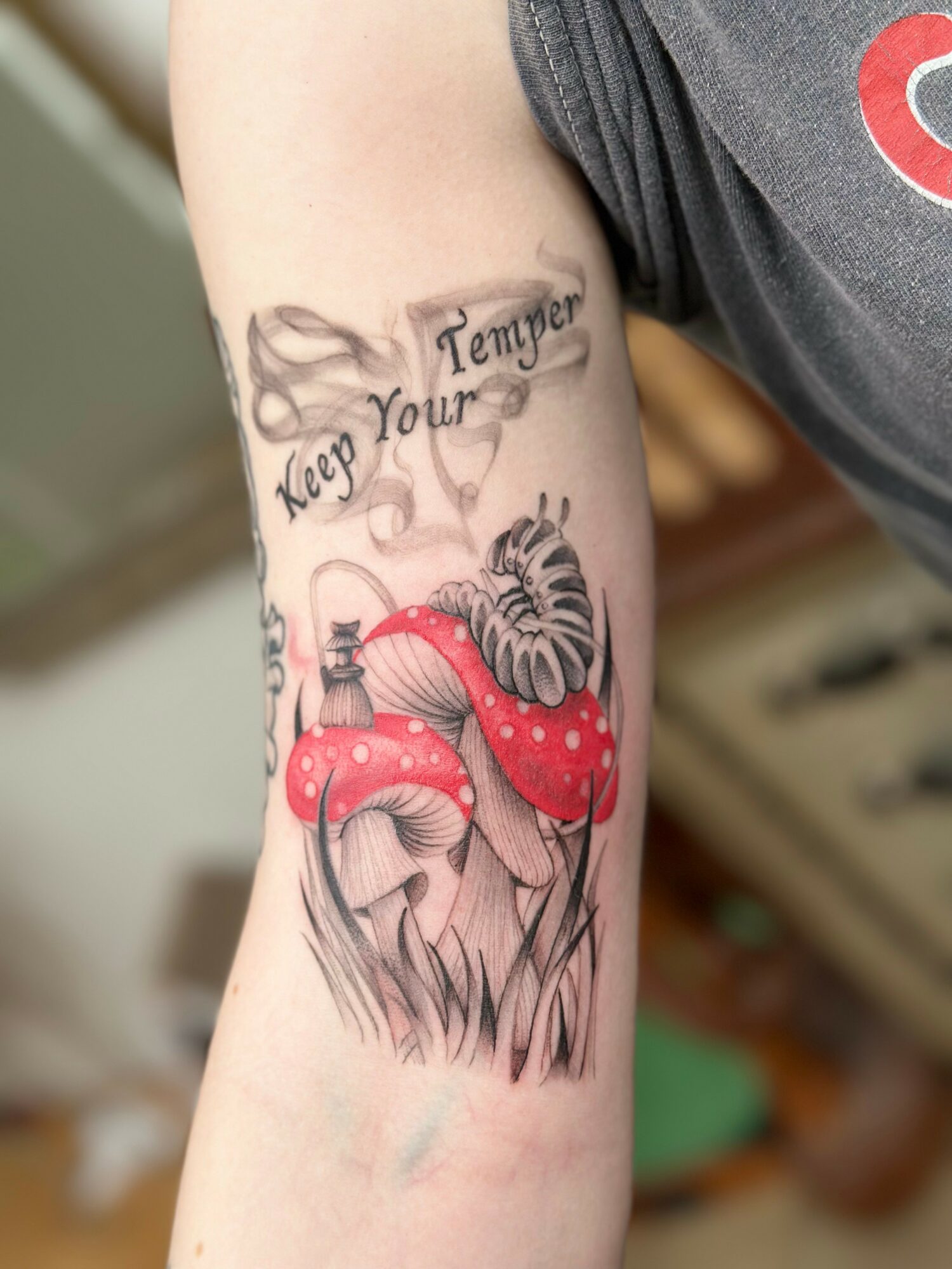 Tattoo of two red mushrooms with white spots and a tiger face, with a banner reading 'Keep Your Tempe'.