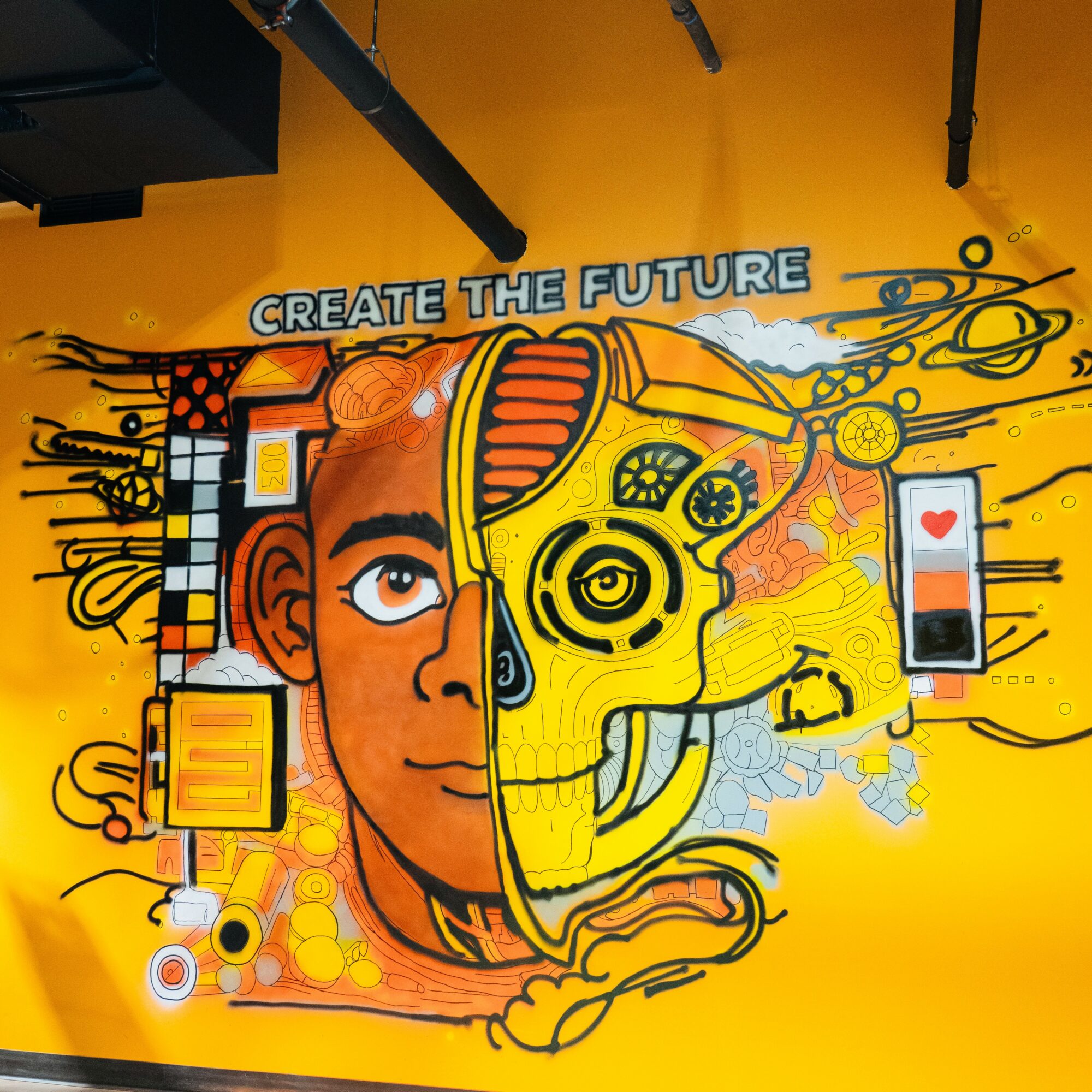 Colorful mural with a human face and a robotic skull, with the phrase 'Create the Future' on a yellow background.