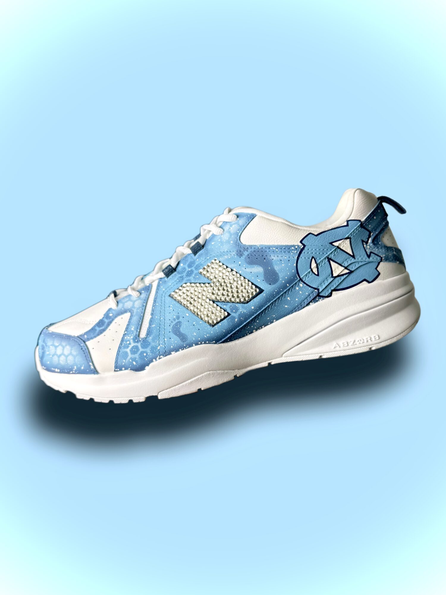 Blue and white athletic shoe with a large letter N on the side, on a light blue background.