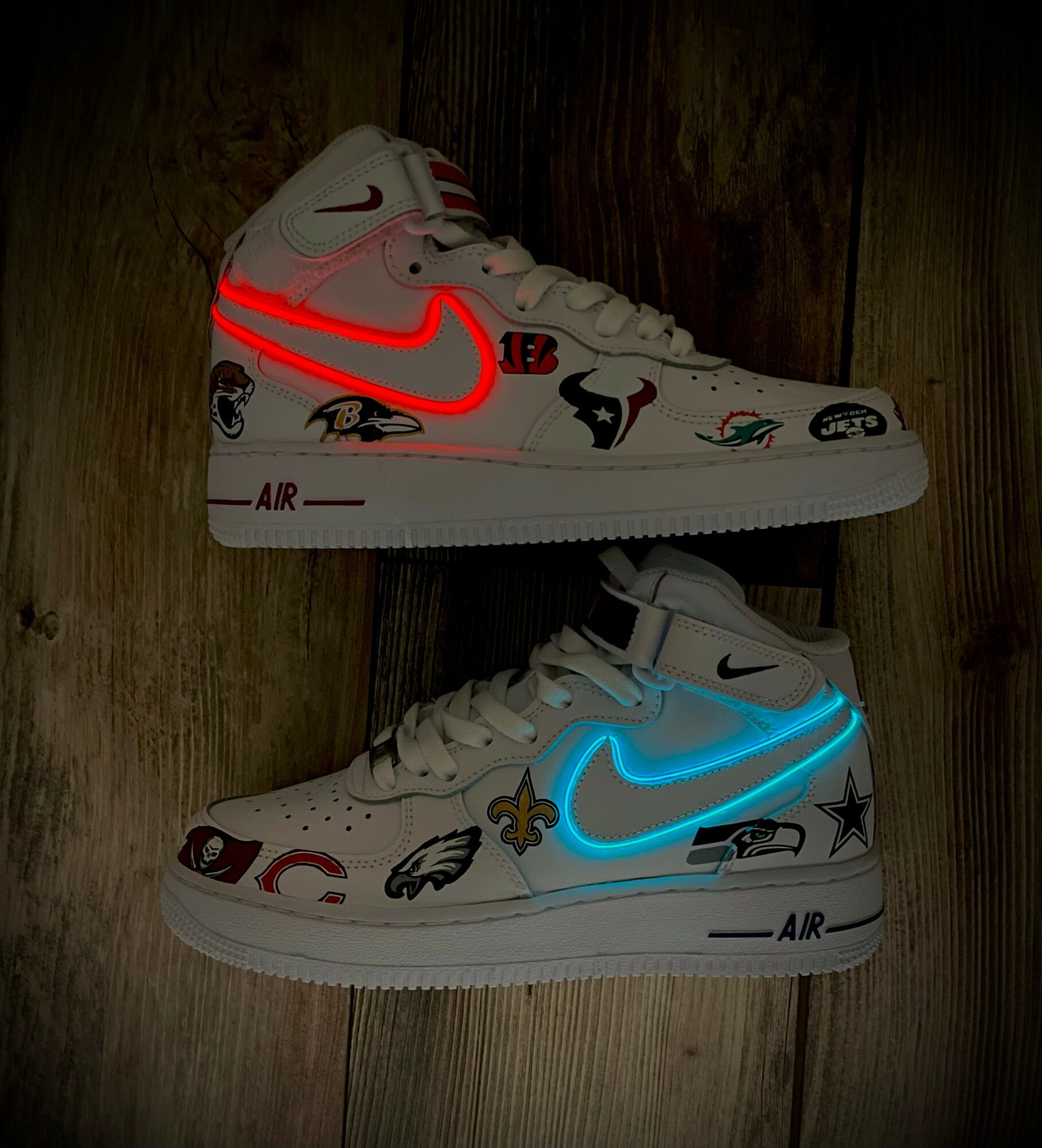 Two white sneakers with colorful logos and glowing Nike swooshes, one with red glow, one with blue glow, on wooden floor.